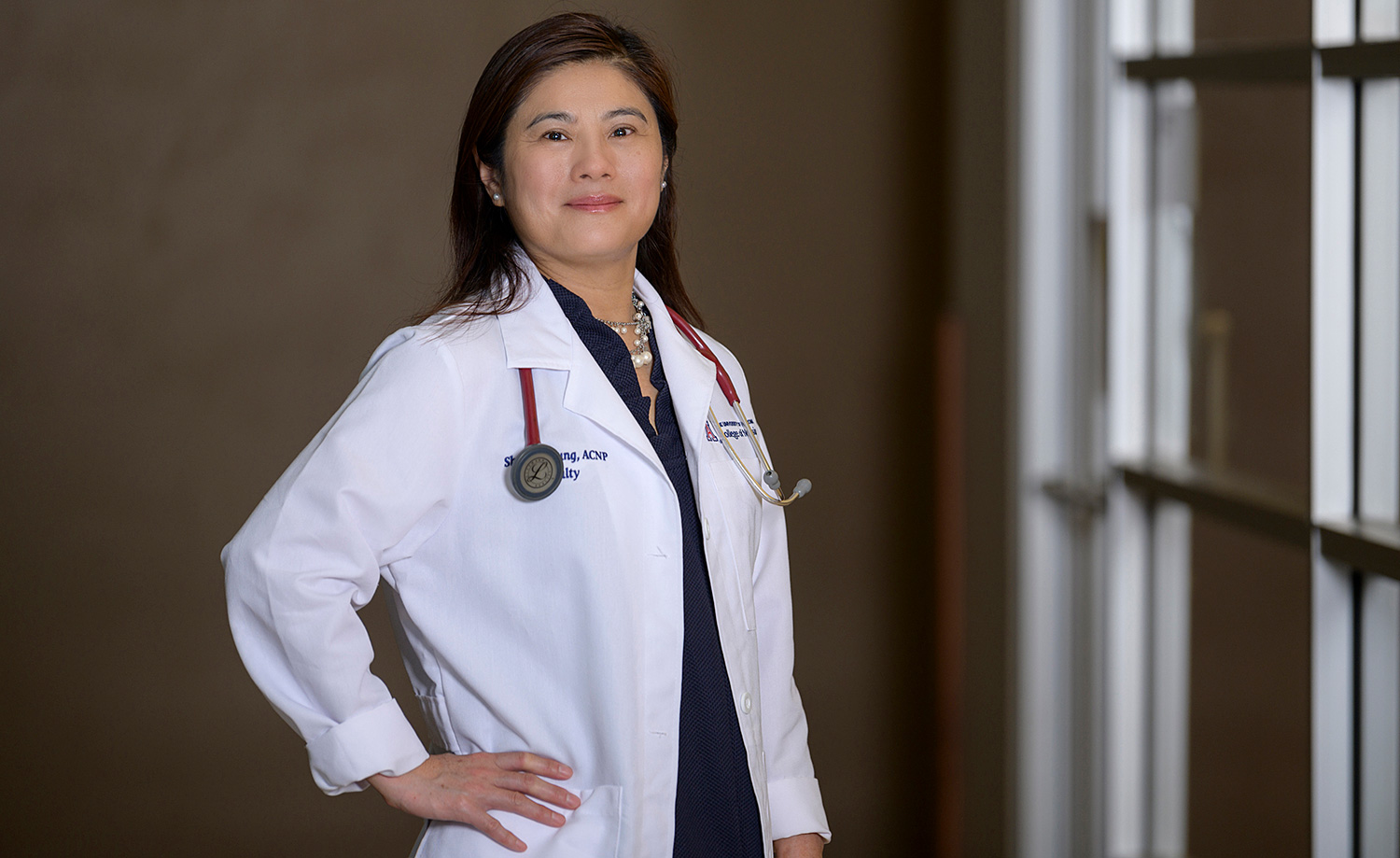 Photo of Shu-Fen-Wung in a lab coat with a stethoscope around her neck.