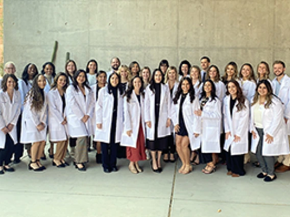 DNP students wearing white coats standing outside in groups