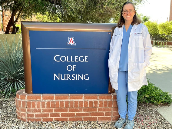 Brittney Marcano standing outside in front of the College of Nursing sign