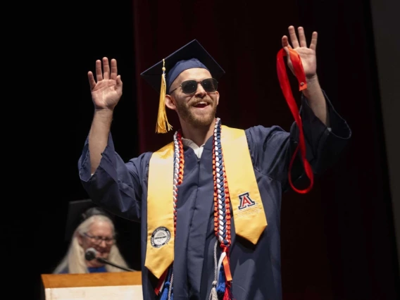 Kyle Breske celebrates as he walks across the stage to be pinned during the University of Arizona College of Nursing spring 2025 convocation.