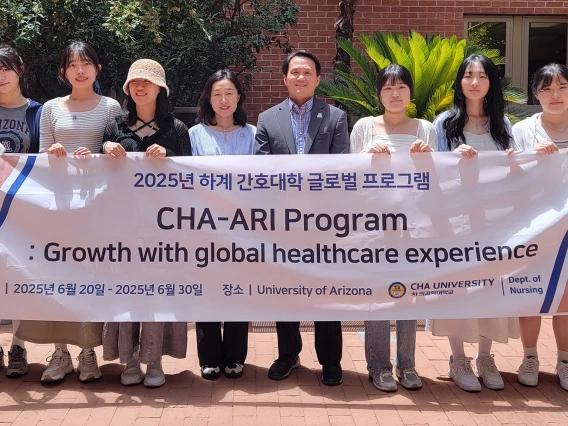 Dean Ahn and visiting students from South Korea holding sign outside