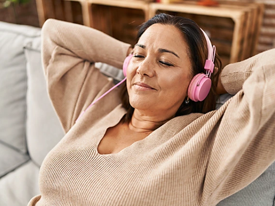 Woman relaxing on couch listening to music