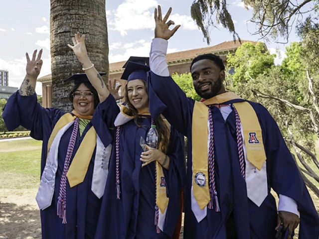 Three college of Nursing graduates standing outside 