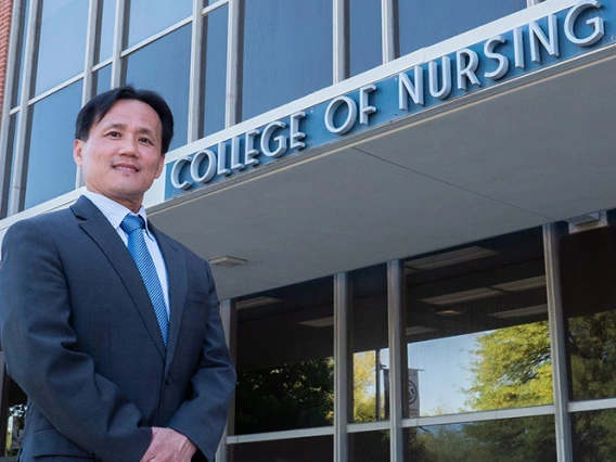 Dean Ahn standing in front of the College of Nursing building entrance.