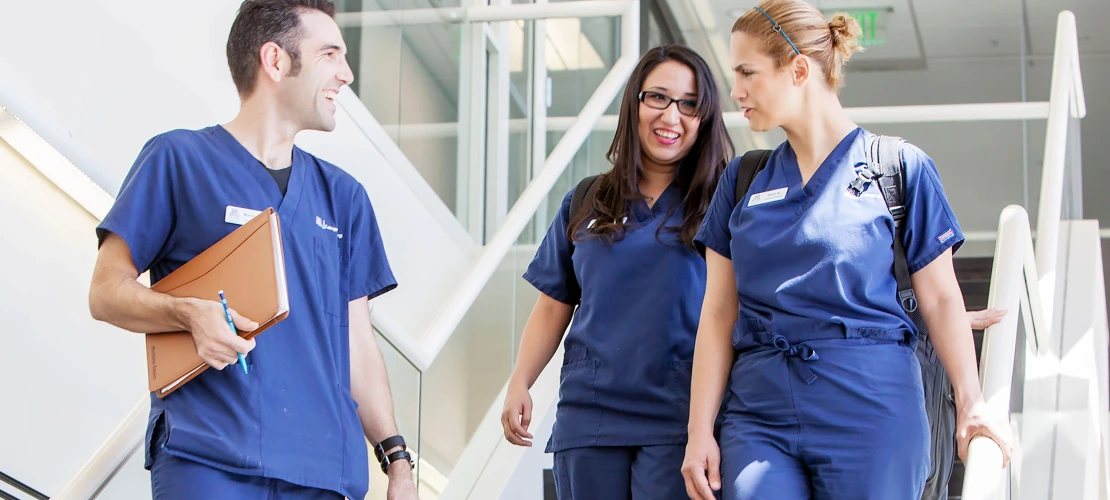 Three College of Nursing students talking while walking