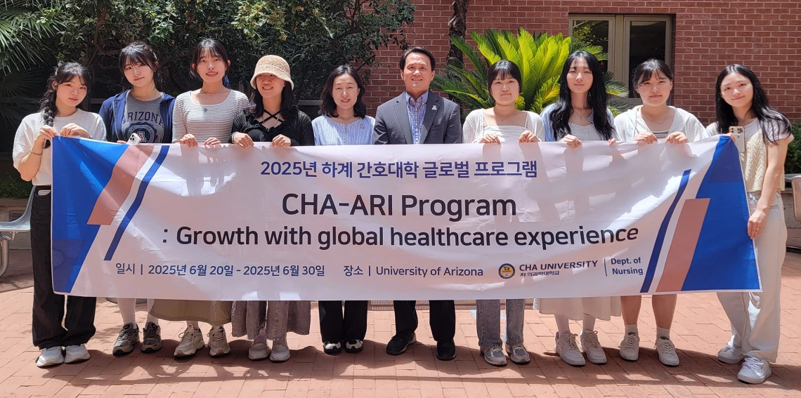 Dean Ahn and visiting students from South Korea holding sign outside