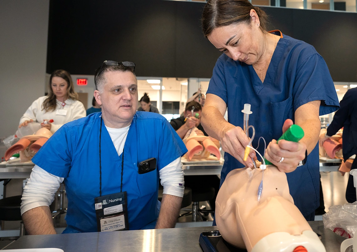 DNP instructor teaching a student to intubate a patient.
