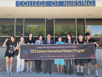 Group of students standing in front of the Nursing building.