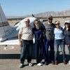 Five people standing in front of air plane