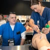 DNP instructor teaching a student to intubate a patient.
