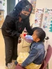 Chinle nurse student using an inhaler on a female child